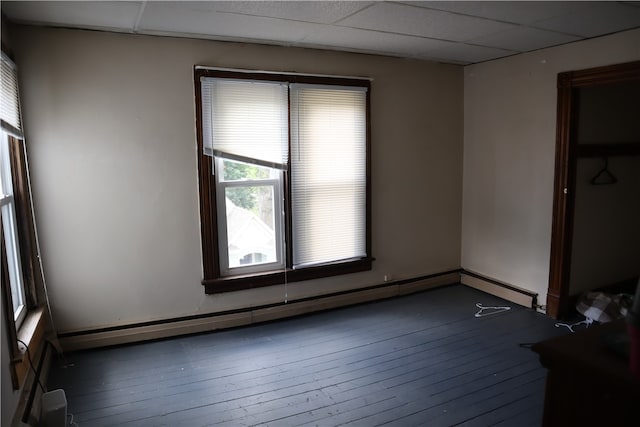 spare room featuring a paneled ceiling and dark hardwood / wood-style flooring