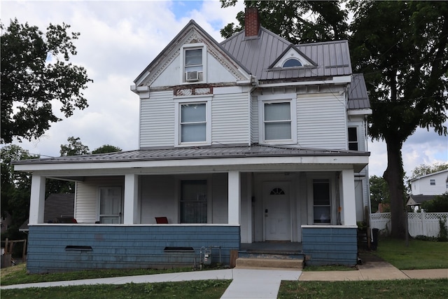 victorian house featuring a porch and cooling unit