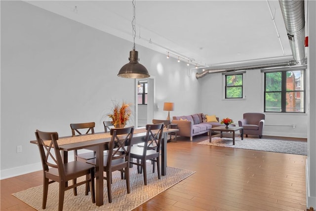 dining room featuring track lighting and hardwood / wood-style flooring