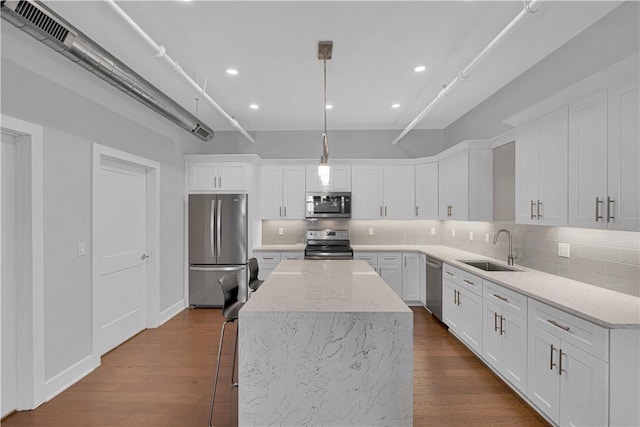 kitchen with white cabinets, decorative light fixtures, stainless steel appliances, and sink