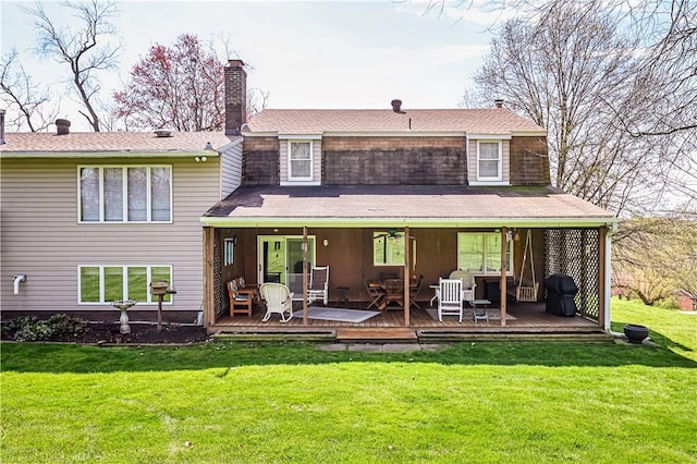 back of house with a wooden deck and a yard