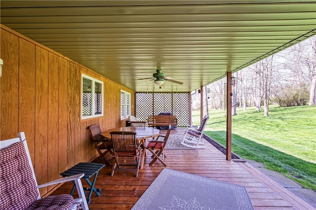 deck featuring ceiling fan and a lawn