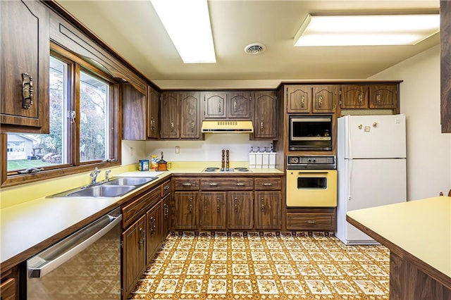 kitchen featuring wall oven, dishwasher, built in microwave, white refrigerator, and sink