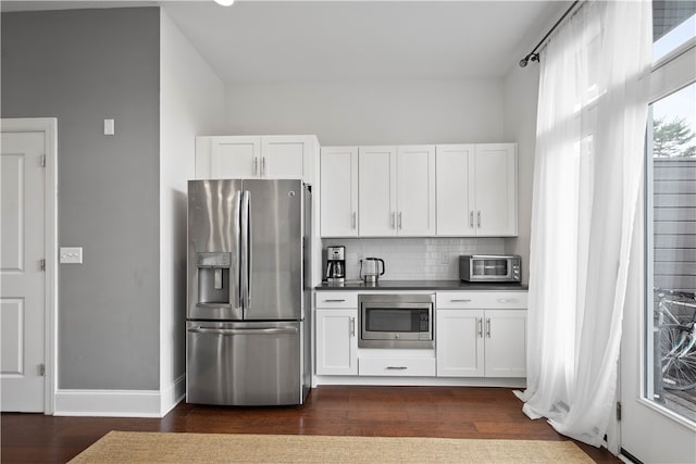 kitchen featuring stainless steel appliances, white cabinets, tasteful backsplash, and dark hardwood / wood-style flooring