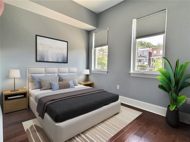 bedroom with multiple windows and dark hardwood / wood-style flooring