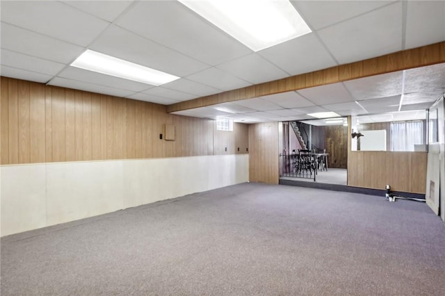 basement with carpet floors and wood walls