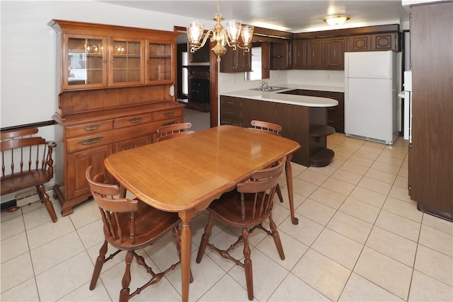 tiled dining room featuring a chandelier and sink