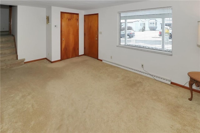 carpeted empty room with a baseboard heating unit