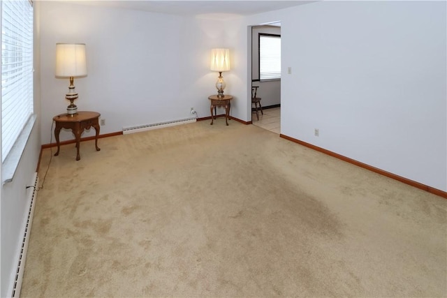 spare room with light carpet and a baseboard radiator