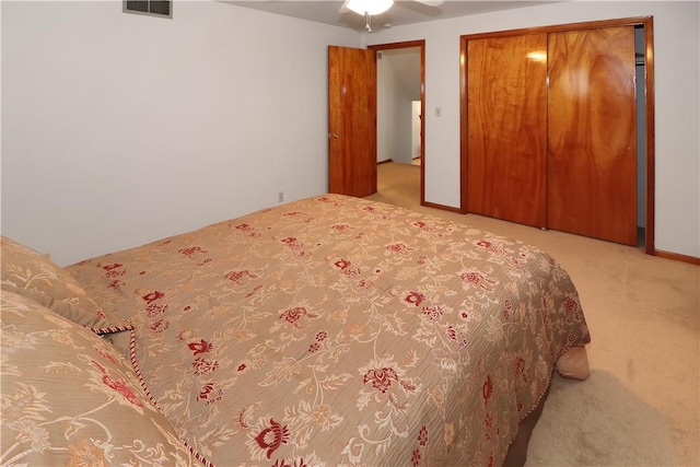 carpeted bedroom with ceiling fan and a closet