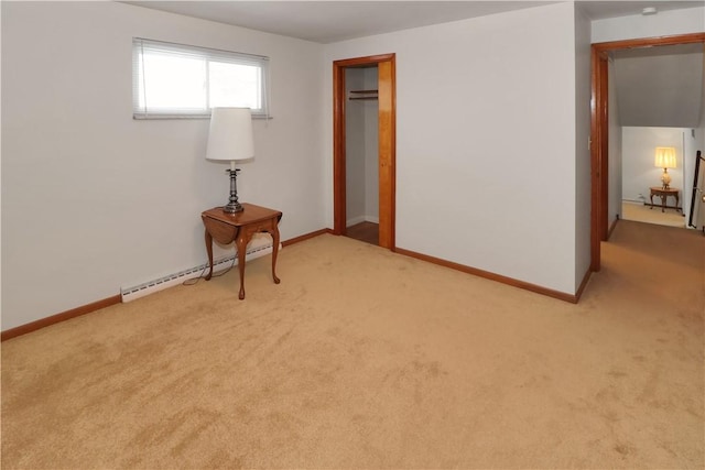 carpeted spare room featuring baseboard heating