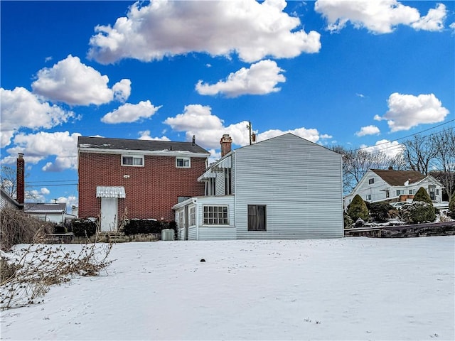 view of snow covered rear of property