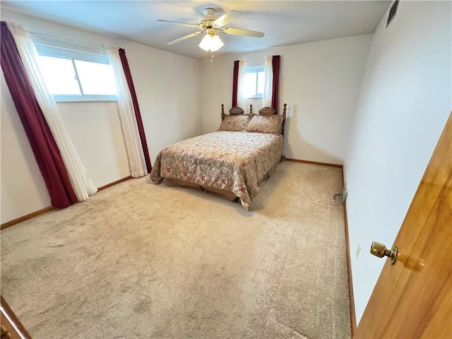 carpeted bedroom featuring ceiling fan and multiple windows