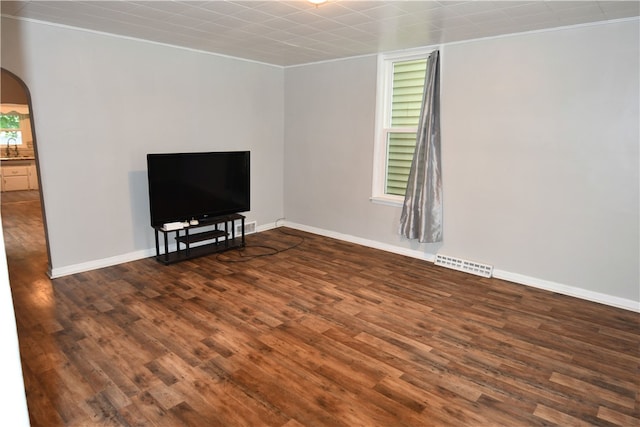 unfurnished living room featuring sink, crown molding, and dark hardwood / wood-style floors