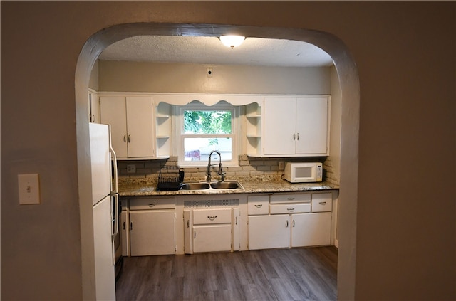 kitchen with dark hardwood / wood-style floors, tasteful backsplash, white appliances, and sink