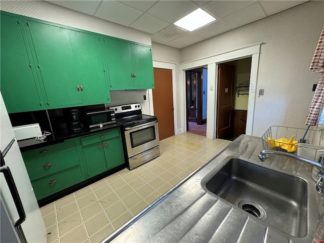 kitchen featuring light tile patterned flooring, sink, stainless steel appliances, and green cabinetry