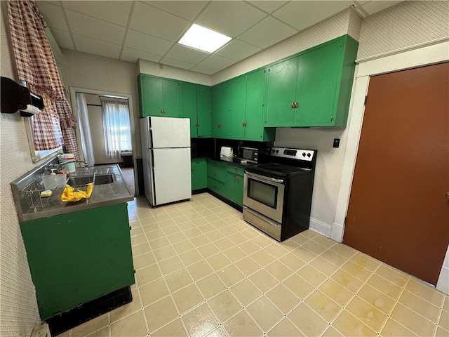 kitchen featuring sink, green cabinets, white fridge, and stainless steel electric range