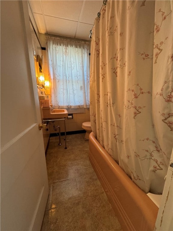 bathroom featuring shower / bath combo, a paneled ceiling, and toilet