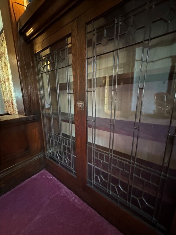 interior space featuring wooden walls and carpet