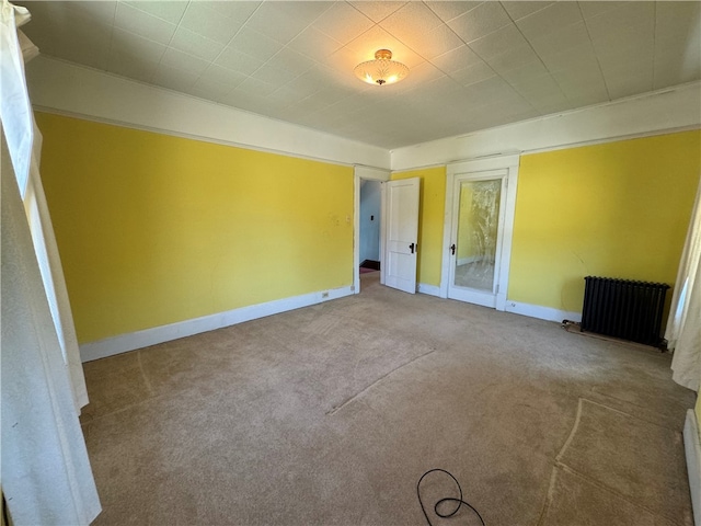 unfurnished bedroom featuring light carpet and radiator