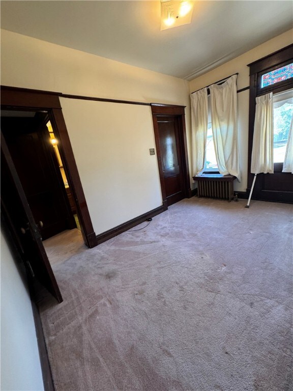 entrance foyer with light colored carpet and radiator