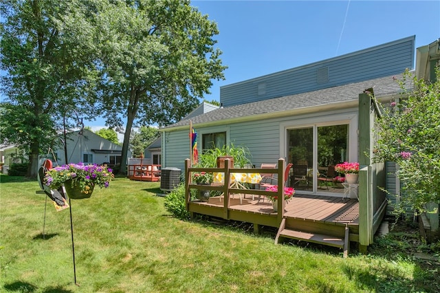 rear view of house with a deck, central AC unit, and a lawn