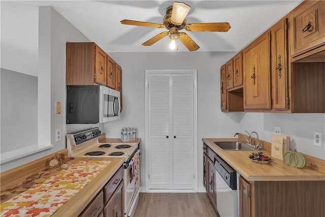 kitchen featuring white electric range, dishwashing machine, sink, light wood-type flooring, and ceiling fan