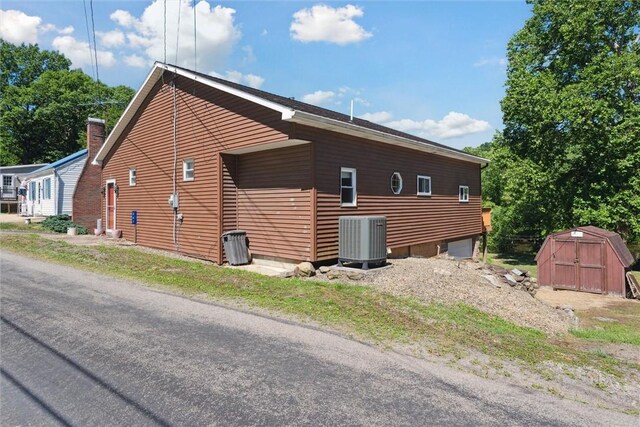 view of side of property featuring a storage shed and central AC unit