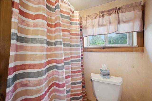 full bathroom with toilet and a shower with curtain