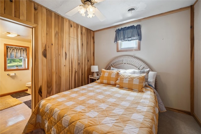 bedroom featuring ornamental molding, ceiling fan, and wood walls