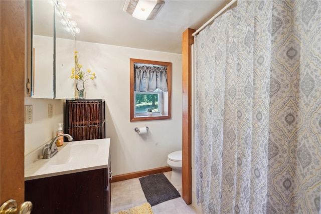 bathroom with toilet, vanity, and baseboards