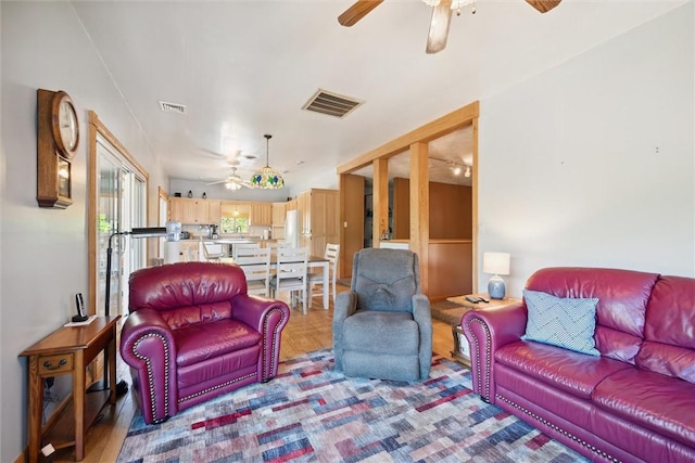 living room featuring visible vents and ceiling fan