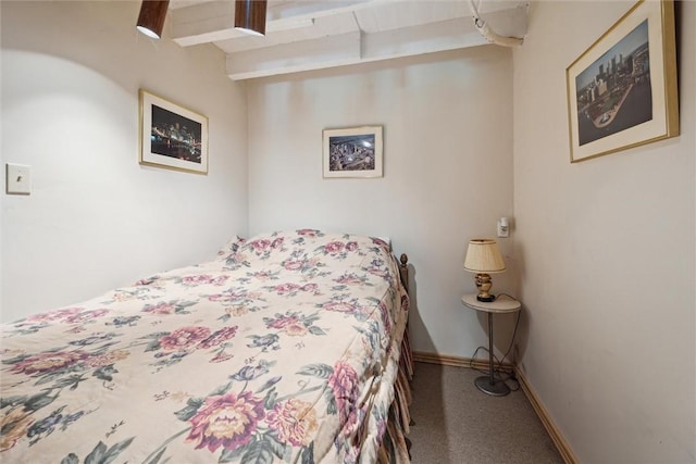 carpeted bedroom with beam ceiling and baseboards