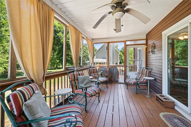 sunroom featuring ceiling fan, a wealth of natural light, and wood ceiling