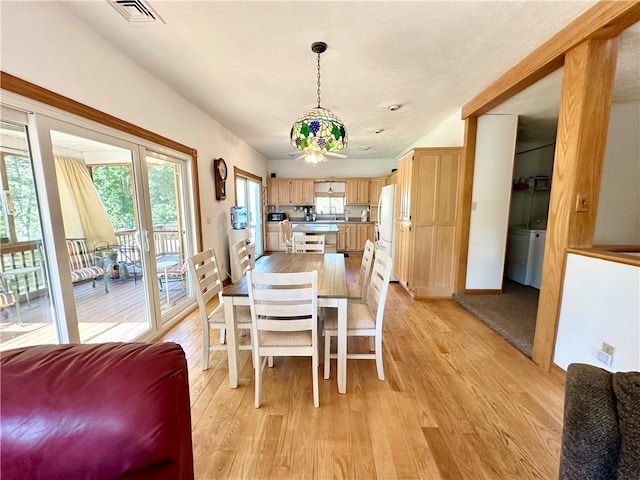 dining area with a wealth of natural light and light hardwood / wood-style flooring