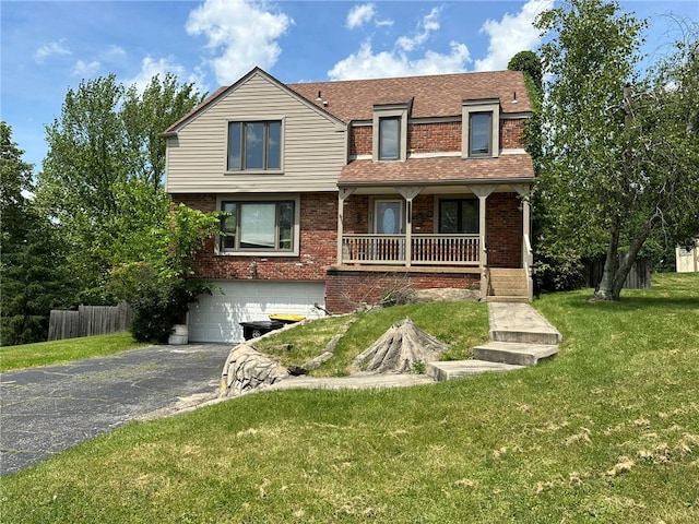 view of front facade with a garage, a porch, and a front lawn