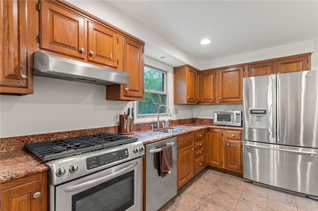 kitchen featuring stainless steel appliances, sink, and stone counters