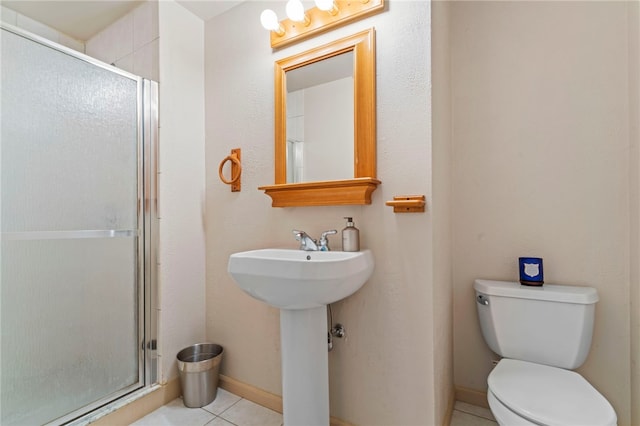 bathroom with an enclosed shower, sink, tile patterned floors, and toilet