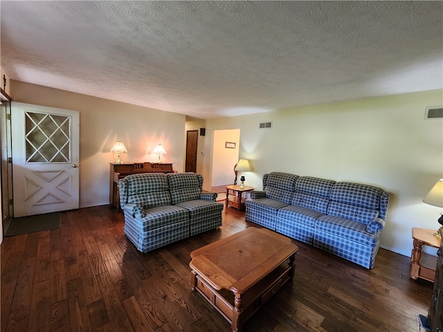 living room featuring a textured ceiling and dark hardwood / wood-style flooring