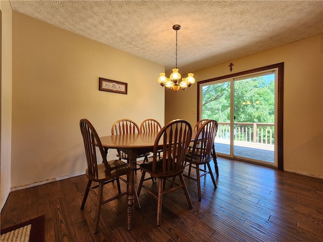 dining room with a textured ceiling, an inviting chandelier, and dark hardwood / wood-style floors