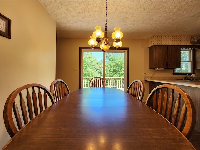 dining room with a chandelier and a textured ceiling