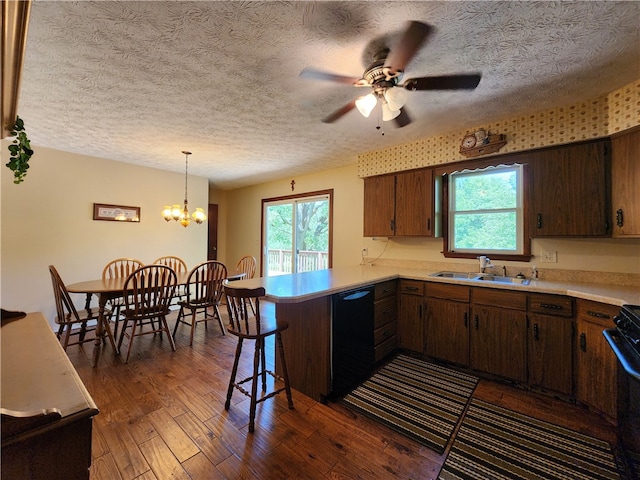 kitchen featuring kitchen peninsula, dark hardwood / wood-style floors, sink, hanging light fixtures, and black appliances