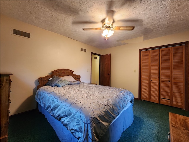 bedroom with ceiling fan, dark carpet, a closet, and a textured ceiling