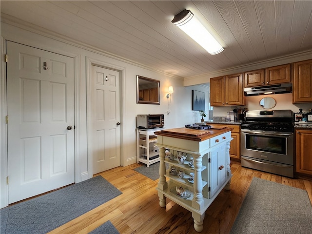 kitchen featuring stainless steel range oven, wooden counters, light wood-type flooring, and ornamental molding