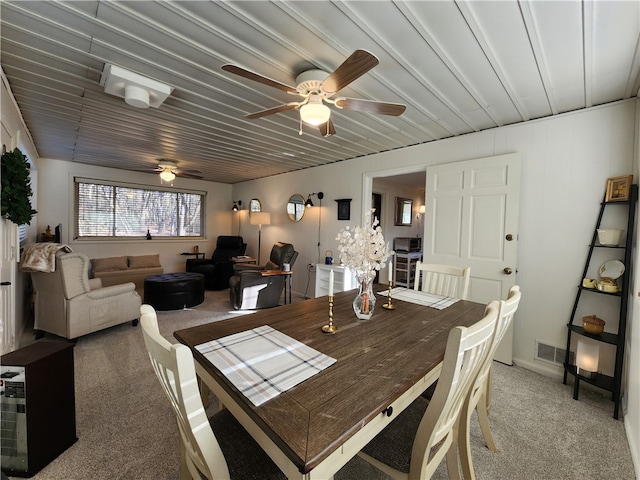 carpeted dining space featuring ceiling fan