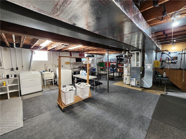 basement featuring sink, heating unit, and independent washer and dryer