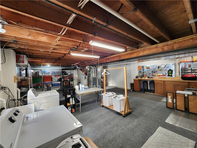 basement with a workshop area, carpet flooring, gas water heater, and washer and dryer