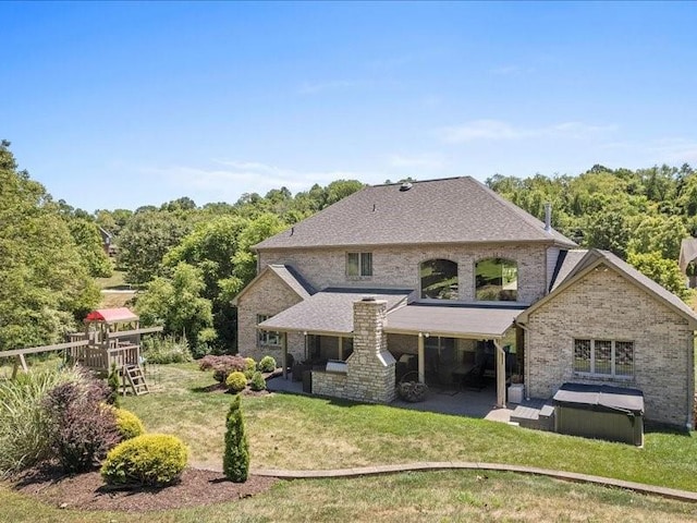 rear view of property with a lawn and a patio area