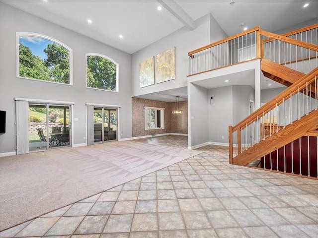 unfurnished living room featuring light carpet and a high ceiling