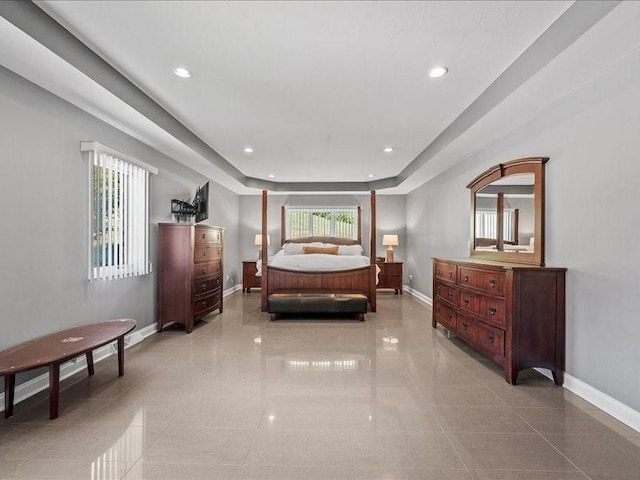 tiled bedroom featuring a tray ceiling